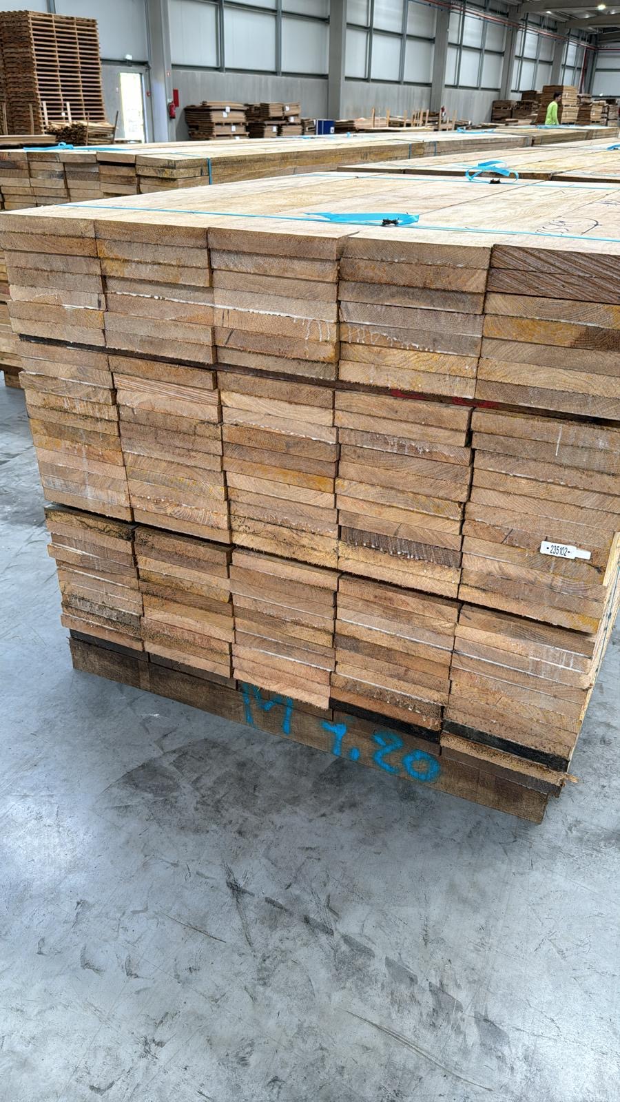 Oak edged boards stacked on pallets in warehouse storage