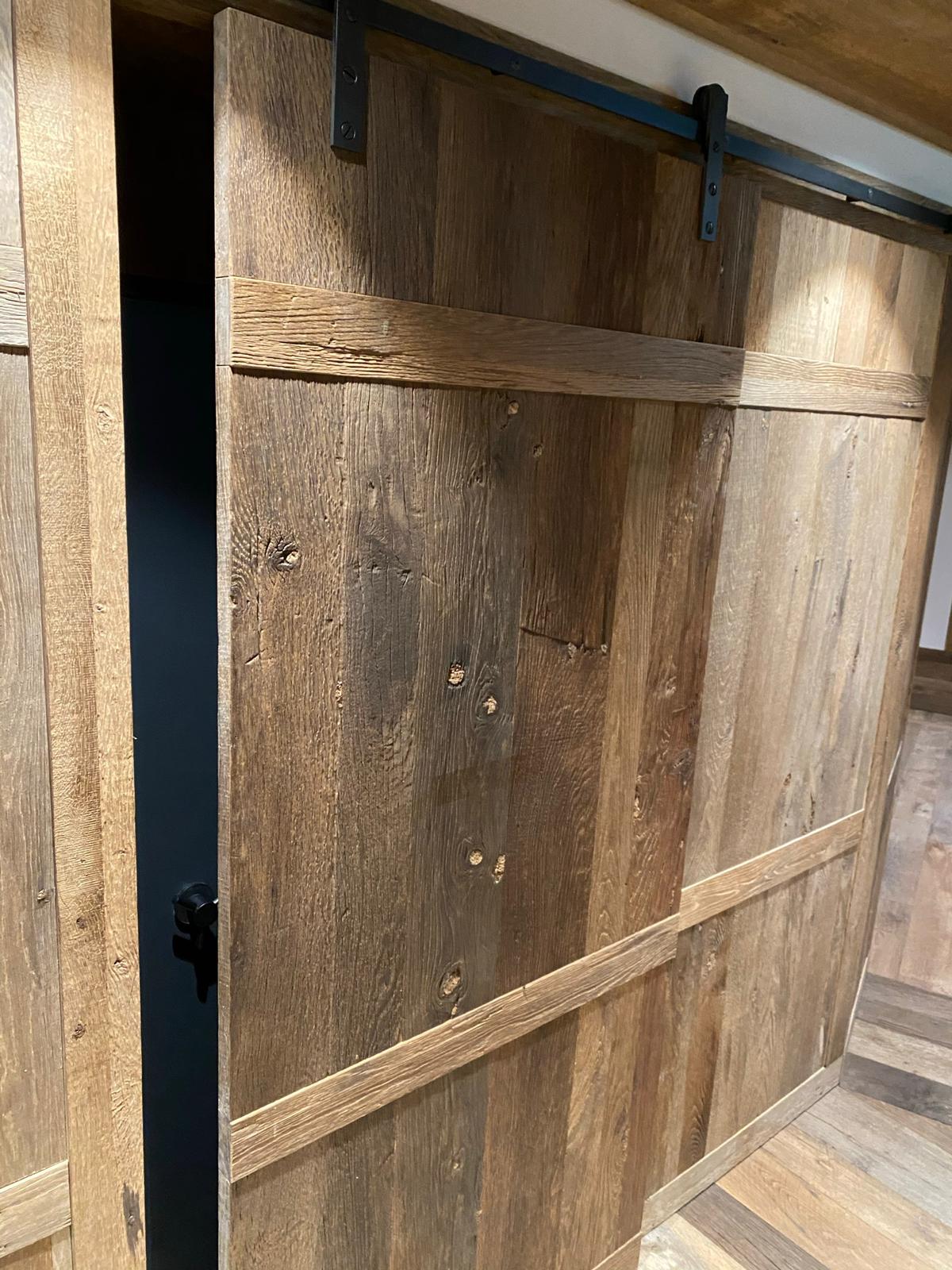 Finished reclaimed oak sliding door and wall panel with original patina