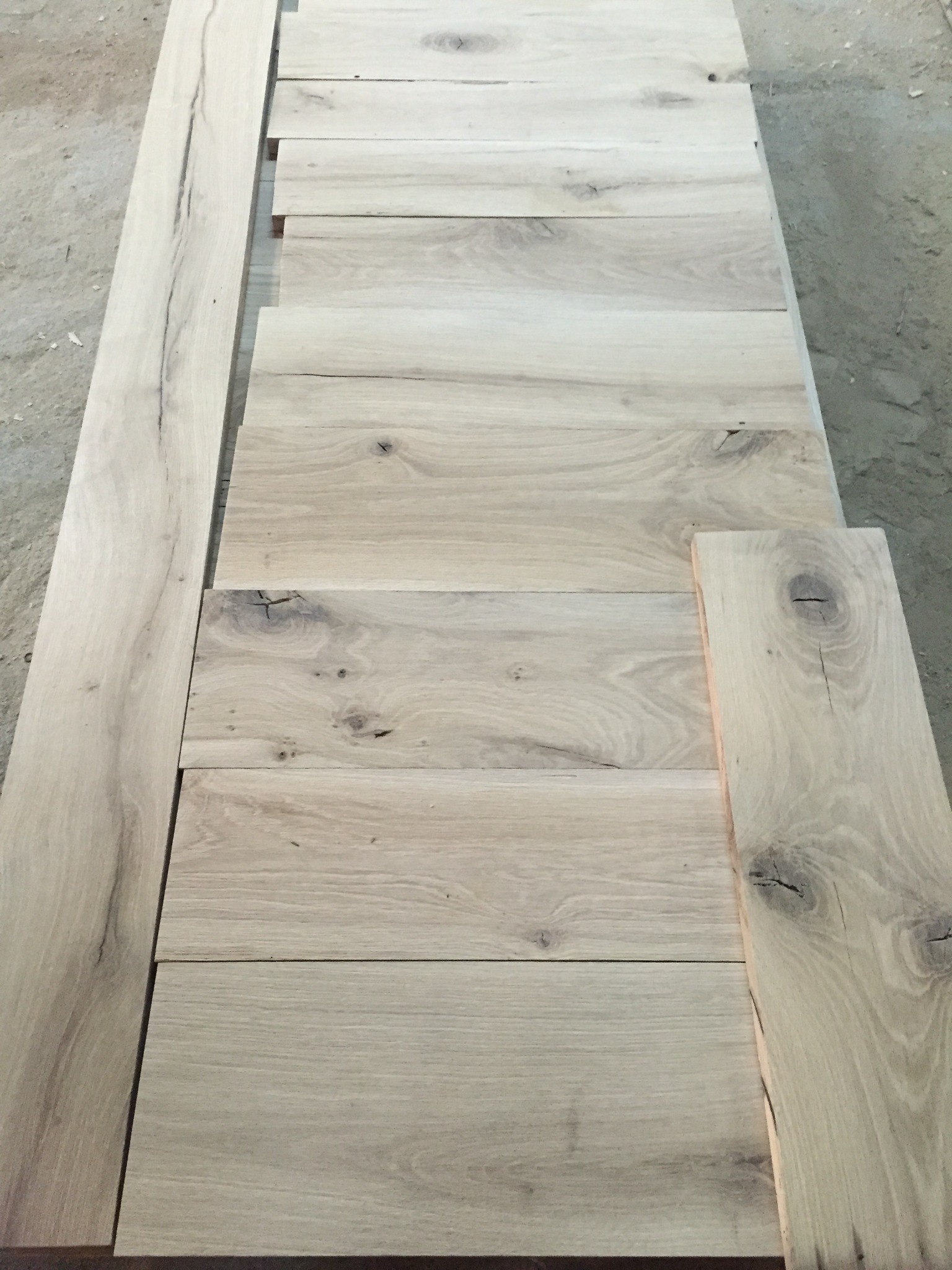 Reclaimed oak boards laid out for selection, matching, and preparation before project use
